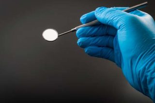 Dental nurse's hand with mirror